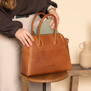 Styled Fit Perspective of Marsala Full-Grain Leather Handbag نسائي on Model - Natural Daylight Drape