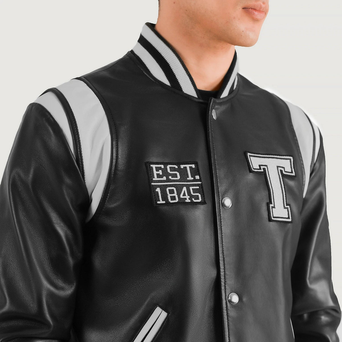 Close-Up Detail of Varsity &amp; Snap Button Hardware on Liberte Texas أسود Leather Varsity جاكيت جلد رجالي